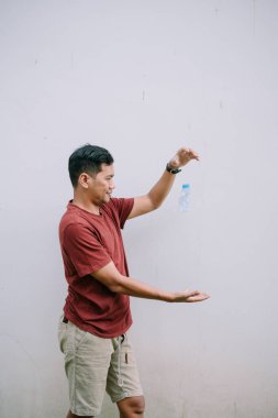 Plastik şişe atan genç bir yetişkin. Atık yönetimi, yeniden kullanım ve geri dönüşüm kavramı