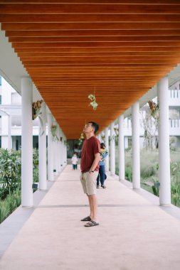 Adam modern mimariye bakıyor. Otel geçidini keşfederken düşünceli bir an.