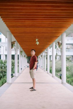 Bir adam modern mimarinin altında bir patikada duruyor. Doğal ışık huzur ortamını aydınlatır..