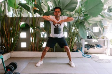 Spor salonunda kettlebell egzersizi yapan bir adam. Kendini adamış egzersizlerle güç kazanıyorum..