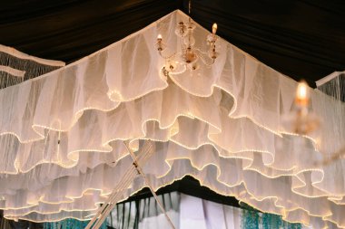 Yumuşak ışıklandırma ve avizeyle süslenmiş zarif bir kubbe, düğünler veya özel toplantılar için rüya gibi ve şenlikli bir ortam yaratıyor.