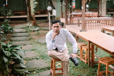 Rahat duruşu olan, açık havanın tadını çıkaran sakin ve düşünceli, sıradan ama zarif bir adam. Huzurlu ortamda derin düşüncelere dalan anları yakalar.