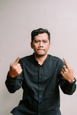 Sinirli adam, orta parmağı küstah bir ifadeyle gösteriyor. Hayal kırıklığı ve hoşnutsuzluk kavramı