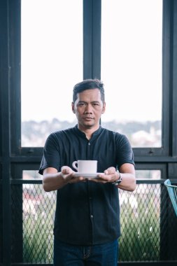 Ciddi bir ifade ve bir bardak içecek sunan bir adamın kapalı çekim, düşünceli göstermek için mükemmel.