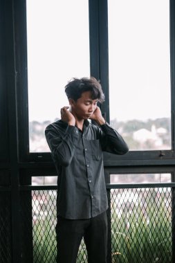 Düşünceli genç adam düşünceli bir içgözlem modunda pencerenin yanında duruyor. Stüdyo resmi