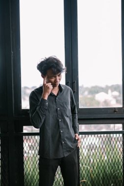 Düşünceli genç adam pencerenin kenarında kayboldu. İç gözlem ya da endişeyi keşfeden kavramsal görüntü