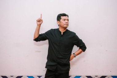 Adam parmağıyla işaret ederek arka planda yeni bir kavram ya da fikir sunuyor. Reklam, sunum ve her türlü iş için uygun..