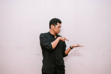 Adam işaret ederek avucunda görünmez bir nesne sergiliyor. Reklam yerleştirme ve tanıtım konsepti