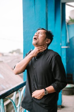 Adam nefes almak için boğuşurken boğazını sıkıca tutuyor. Dışarıda nefes darlığı çeken tıbbi bir acil durum yaşanıyor.