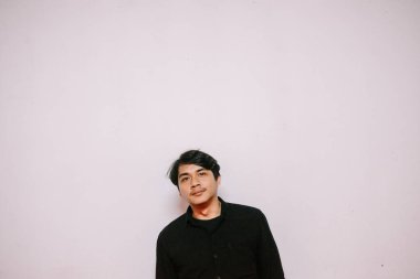 Tarafsız bir arka planda fotokopi alanı olan düşünceli genç adam portresi. Çeşitli kavramlar için mükemmel.