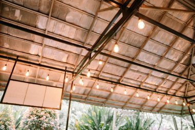 Atmosferik çekim. Kırsal bir mekanda sicim ışıkları var. Arka planlar için ideal ya da doğal atmosferi olan rahat ve şenlikli açık hava olayları için.