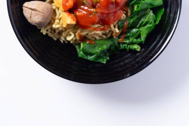 Lezzetli köfteler, taze sebzeler ve keskin bir sos içeren lezzetli bir erişte kasesi.