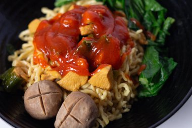 Lezzetli Mie Ayam 'ın yakın çekimi. Tavuklu Endonezya erişte yemeği, köfte ve siyah bir kasede bok çuvalı. Çeşitli mutfaklar ve sağlıklı yiyecekler için mükemmeldir.