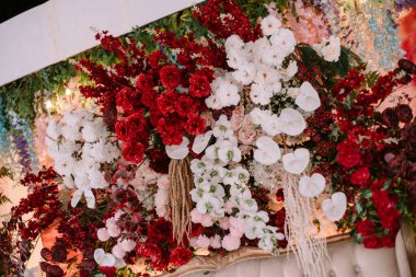 Canlı kırmızı ve saf beyaz çiçekli lüks bir çiçek sergisi etkinlikler ve kutlamalar için zarif bir zemin oluşturur. Sevgi, neşe ve sofistike stil taşımak için mükemmel.