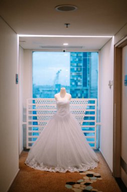 Enfes bir gelinlik, modern bir şehrin ufuk çizgisinin arka planında sergileniyor.. 