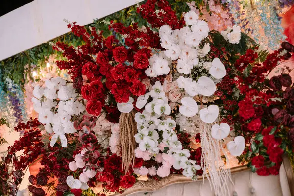 Canlı kırmızı ve saf beyaz çiçekli lüks bir çiçek sergisi etkinlikler ve kutlamalar için zarif bir zemin oluşturur. Sevgi, neşe ve sofistike stil taşımak için mükemmel.