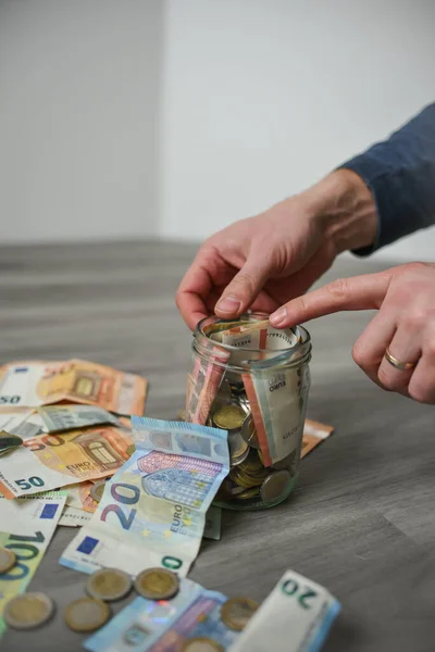 stock image Putting money into the jar, lots of Euro coins and banknotes