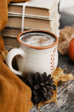 Sıcak baharatlı kahve ve ahşap arka planda bir yığın eski kitap.