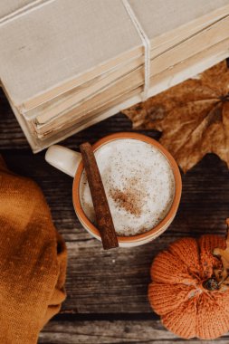 Sıcak baharatlı kahve ve ahşap arka planda bir yığın eski kitap.