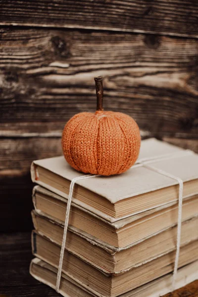 Small handmade pumpkin on old books
