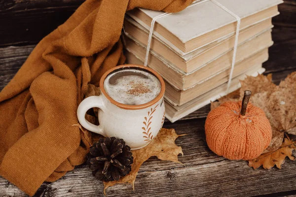 Sıcak baharatlı kahve ve ahşap arka planda bir yığın eski kitap.