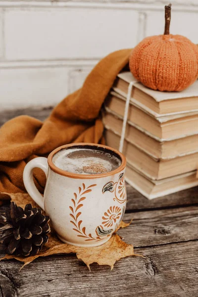 Sıcak baharatlı kahve ve ahşap arka planda bir yığın eski kitap.