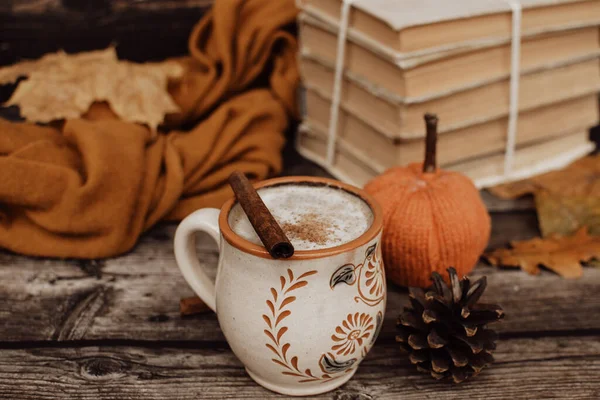Sıcak baharatlı kahve ve ahşap arka planda bir yığın eski kitap.