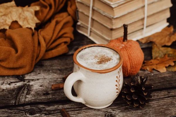 Sıcak baharatlı kahve ve ahşap arka planda bir yığın eski kitap.