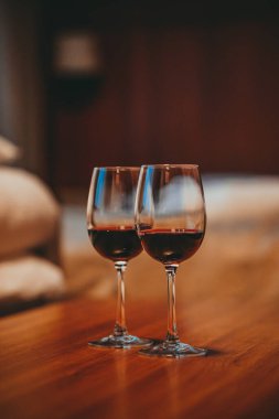 Sıcak bir dairede, kırmızı şarapla dolu iki bardak. 