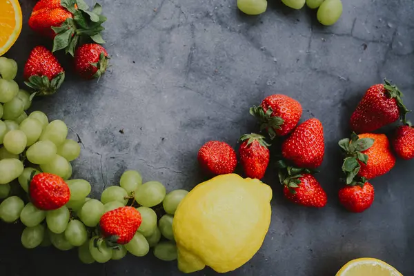 Mutfakta koyu gri arka planda çeşitli meyve ve meyveler var.