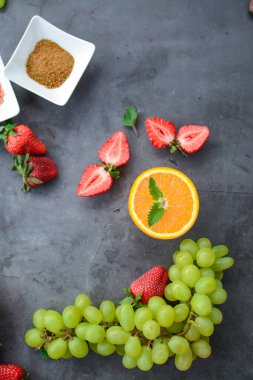 Koyu arkaplanda çeşitli meyve ve meyveler var.