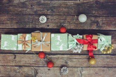 Bir sürü küçük ve şirin Noel hediyesi, renkli bir kağıda sarılmış, masada Noel süsleri.