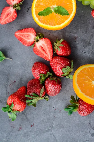 Koyu arkaplanda çeşitli meyve ve meyveler var.