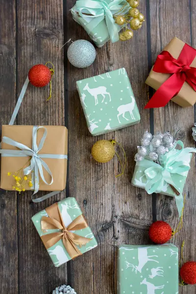 Bir sürü küçük ve şirin Noel hediyesi, renkli bir kağıda sarılmış, masada Noel süsleri.