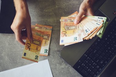 Para tutan eller, euro banknotları ve hesap makinesi