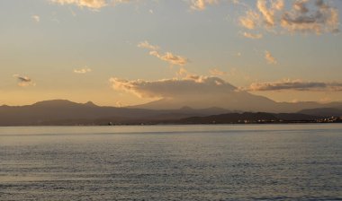 Batan güneş Enoshima, Japonya üzerinde gökyüzünü boyuyor.