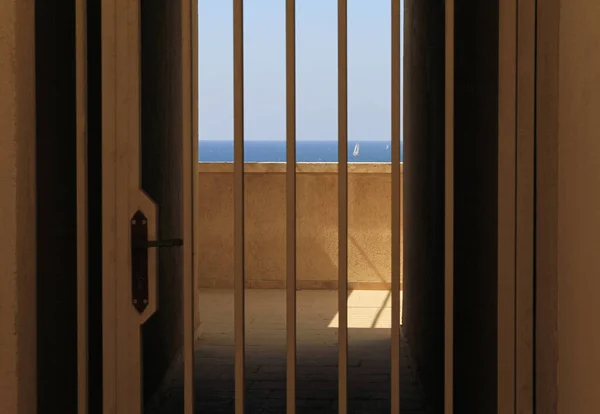 海はテルアビブ イスラエルの家の入り口の金属製のバーを通して見ることができます — ストック写真