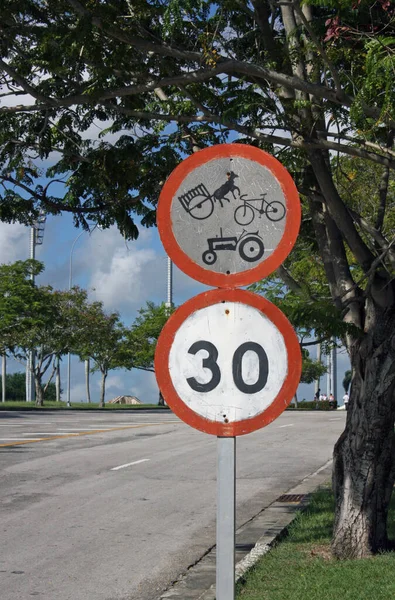 Funny road sign in Cuba with a bicycle, tractor, and horse wagon