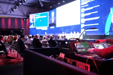 Konferansta ışıklarla ilgilenen teknisyen.