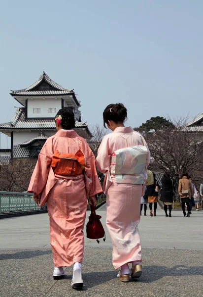 Geleneksel kimonolu iki Japon kadın Kanazawa kalesine doğru yürüyorlar.
