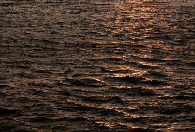 Gün batımında hareket halindeki okyanus dalgalarına yakın çekim