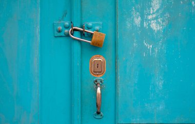 Turkuaz ahşap kapı ve asma kilit.