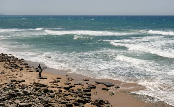 Σέρφερ Την Σανίδα Του Σερφ Στέκεται Στην Παραλία Και Κοιτάζει — Φωτογραφία Αρχείου