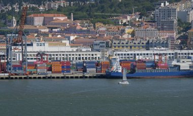 Lizbon, Portekiz - 10 Mayıs 2023: Lizbon, Portekiz limanının ön planda birçok kargo gemisi ve arka planda şehir manzarası