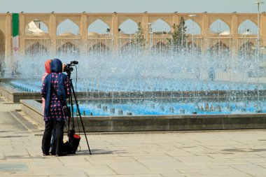 Tahran, İran - 12 Eylül 2018: Elinde kamera olan iki kadın Tahran, İran 'da bir meydanda film çekiyor.