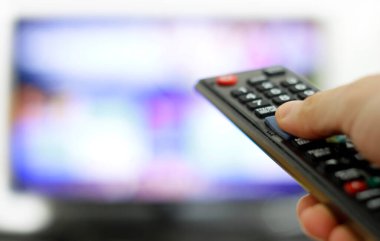 Uzaktan kumanda ve ekran - en sevilen TV programını izliyor