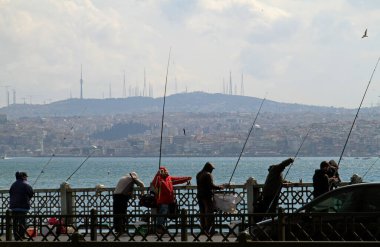 İstanbul, Türkiye - 12 Haziran 2018: İstanbul 'da balıkçı çubuklarıyla bir köprüde yaşayan halk şanslarını denemeye hazır.