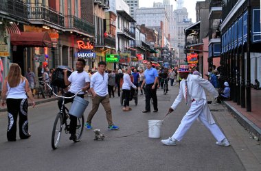 12 Nisan 2018 - New Orleans, Louisiana / ABD: New Orleans, Louisiana 'nın Fransız Mahallesi' ndeki performansı sırasında arka planda kalabalıklar ve neon ışıkları ile sokak sanatçısı.