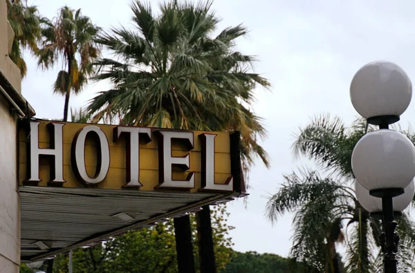 バックグラウンドにヤシの木が付いたブティックホテルにホテルサイン — ストック写真