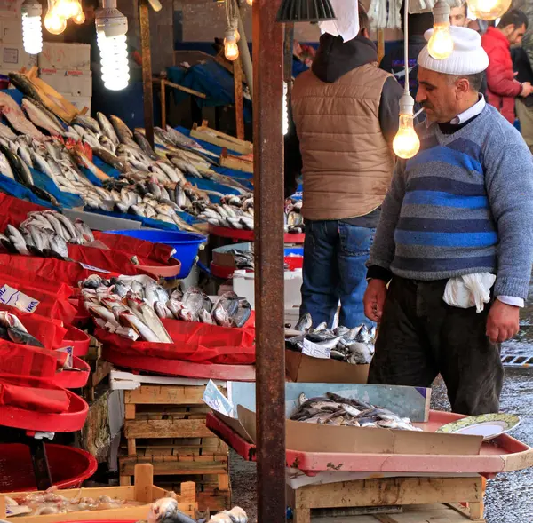 İstanbul, Türkiye - 15 Şubat 2019: İstanbul 'da balıkçı sigara içerken günün avını balık pazarında satıyor